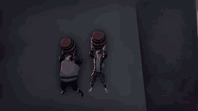 two men carrying barrels on their heads in a dark room