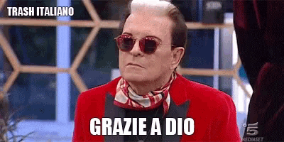 a man wearing sunglasses and a red jacket is sitting in front of a sign that says trash italiano .