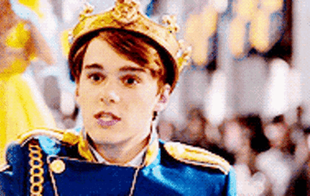 a young man is wearing a crown and a blue and gold uniform .