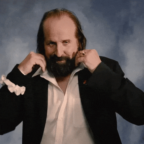 a man with a beard wearing a black jacket and a white shirt