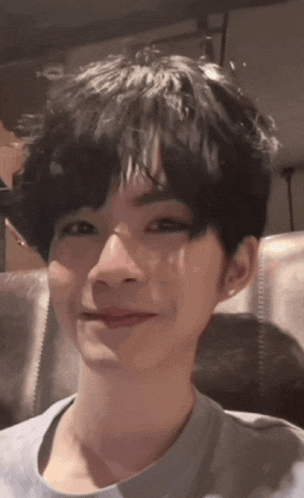 a close up of a person 's face with short black hair