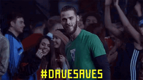 a man in a green shirt is standing in front of a crowd with #davesaves written on the screen behind him