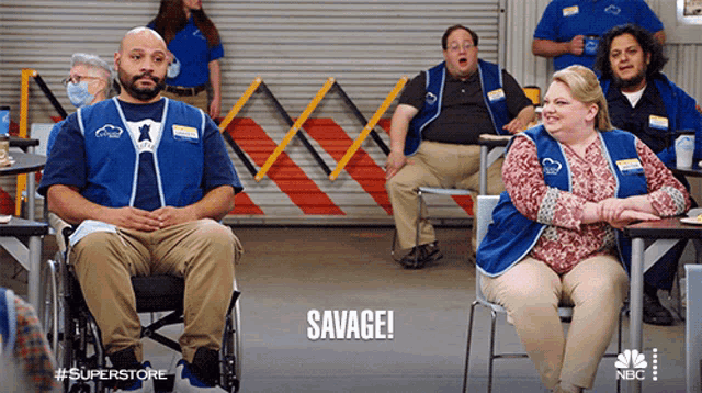 a man in a wheelchair is sitting in front of a group of superstore workers