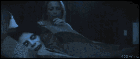 a woman is laying on a bed next to a man with a face painted on his face .