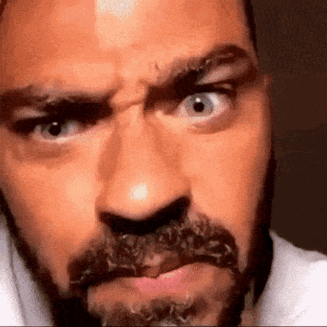a close up of a man 's face with a beard