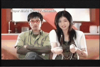 a man and a woman are playing super mario galaxy on the nintendo wii