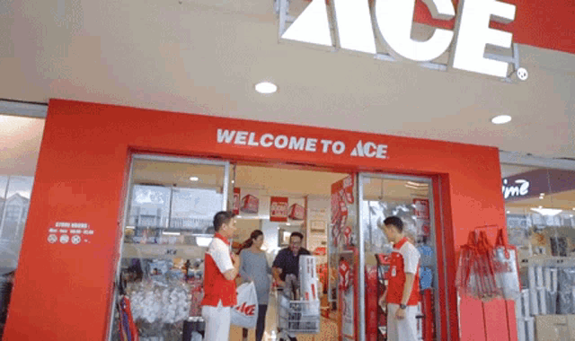 a group of people are standing outside of a store that says welcome to ace