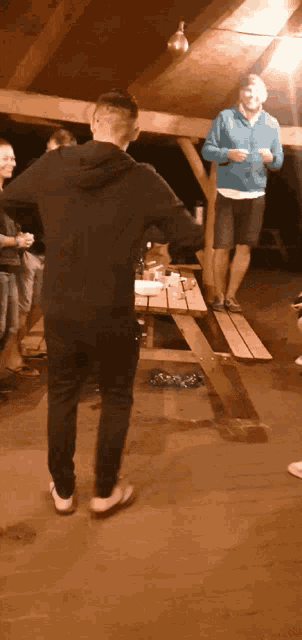 a group of people are standing around a picnic table