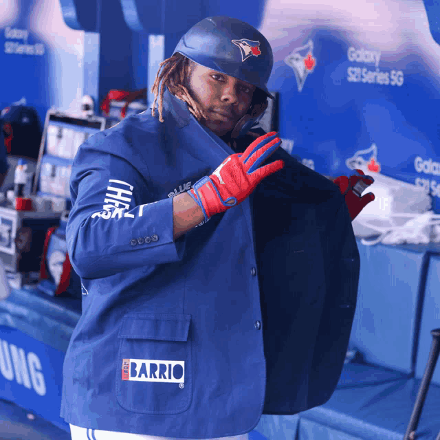 a baseball player wearing a blue jacket with the word barrio on it
