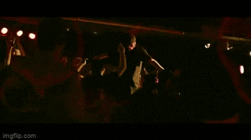 a man is playing a guitar in front of a crowd of people at a concert .