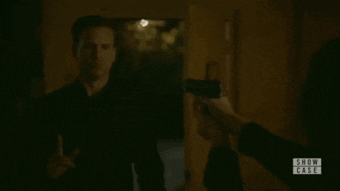 a woman is holding a gun in front of a lamp in a show case scene .
