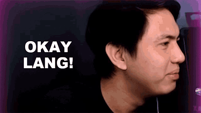 a close up of a man 's face with the words `` okay lang '' written on the bottom .