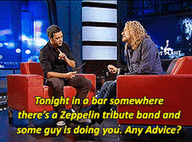 a man is sitting in a red chair talking to another man on a tv show