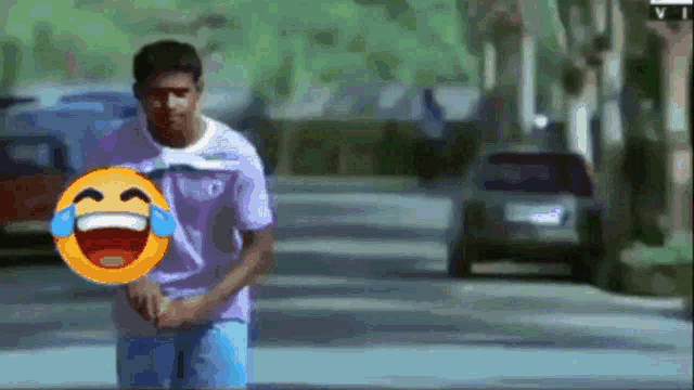 a man holding a smiley face with tears coming out of his eyes is walking down a street
