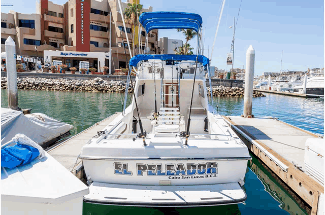 a white boat with the name el peleador on the back