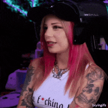 a woman with pink hair is wearing headphones and a white shirt that says a f * cking