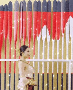 a woman stands in front of a wall of red and white arrows