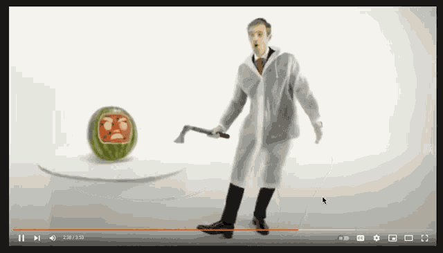 a video of a man holding an axe next to a carved watermelon
