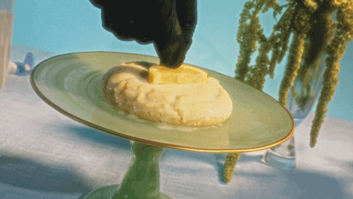 a green plate with a piece of butter on top