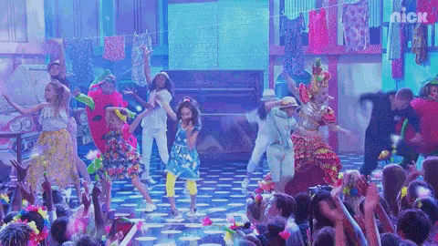 a group of people are dancing on stage in front of a crowd .