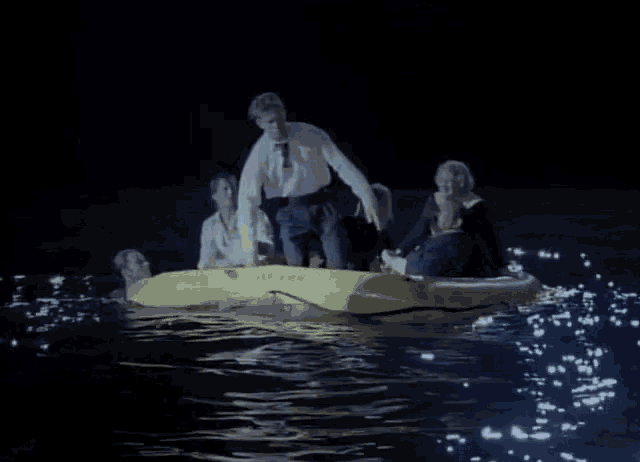 a group of people in a raft in the water at night