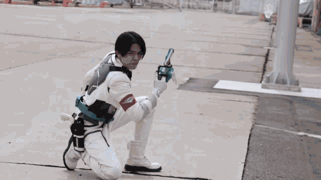 a man with wings is kneeling down with a gun
