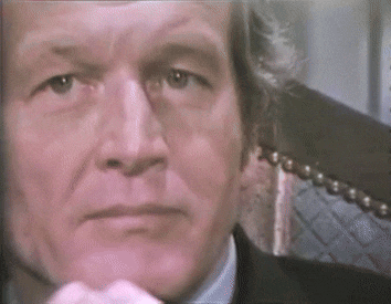 a close up of a man 's face in a suit and tie