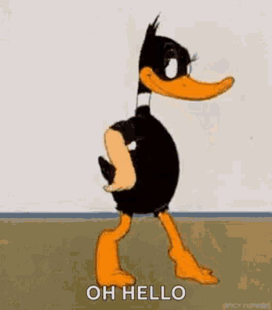 daffy duck is standing next to a wall in a room .