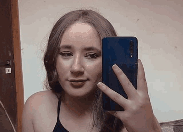 a young woman is taking a selfie with her cell phone