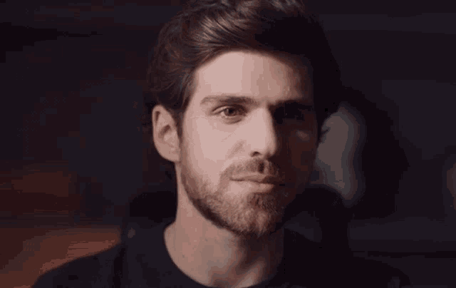 a man with a beard wearing a black shirt
