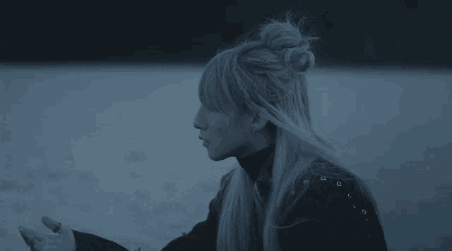a woman with long blonde hair is wearing a black turtleneck sweater