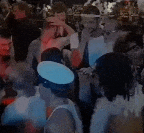 a crowd of people are gathered in a dark room at a party .