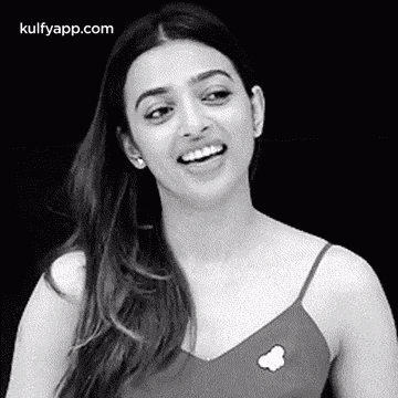 a black and white photo of a woman smiling and laughing .