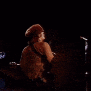 a man is singing into a microphone on a stage .