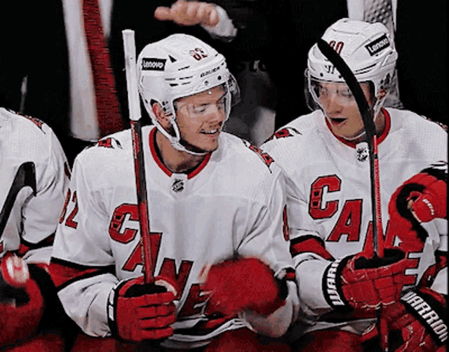 a hockey player wearing a white jersey with the letter g on it
