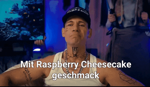 a man wearing a hat and a tank top with the words mit raspberry cheesecake geschmack on the bottom