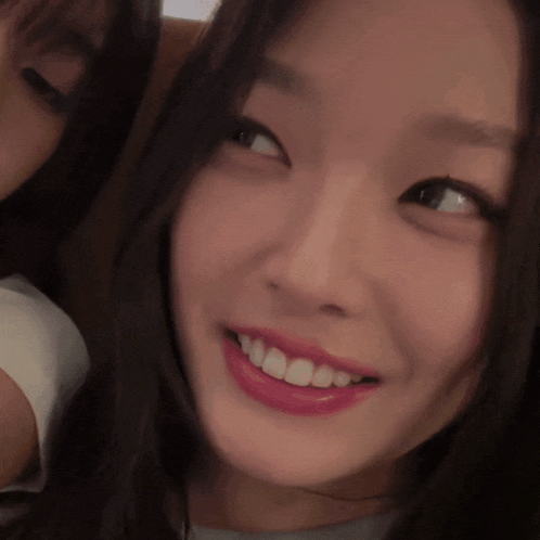 a close up of a woman 's face with a smile