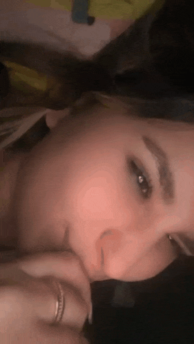 a close up of a woman 's face with her hand on her mouth .