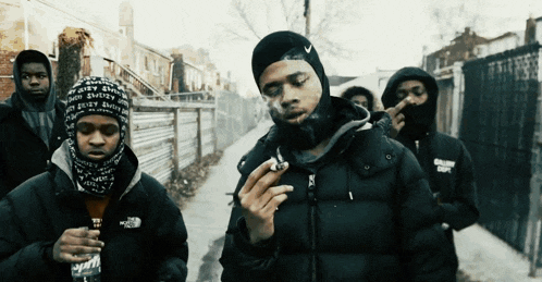 a man smoking a cigarette while wearing a north face jacket