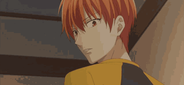 a close up of a person with orange hair wearing a yellow shirt and black sleeves .