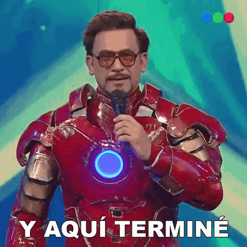 a man in a iron man suit is holding a microphone and says y aqui termine