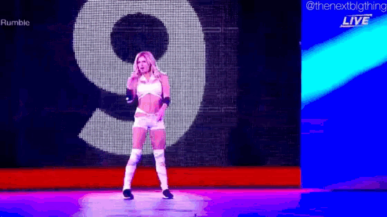 a woman is dancing in front of a large number 9