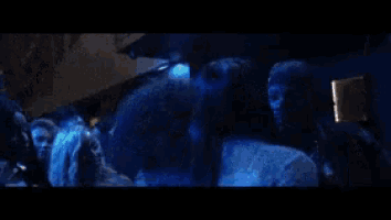 a man is touching a woman 's face in a blue light