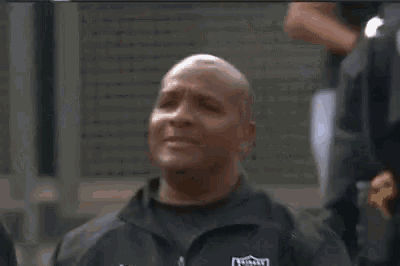 a man wearing a raiders jacket looks at the camera with his eyes closed