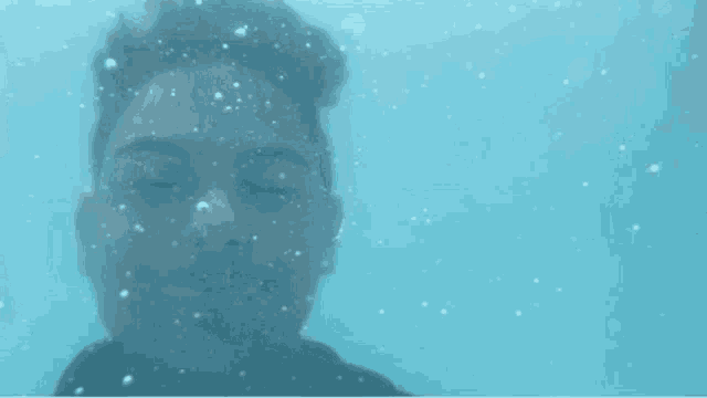 a young man with braces is smiling underwater .