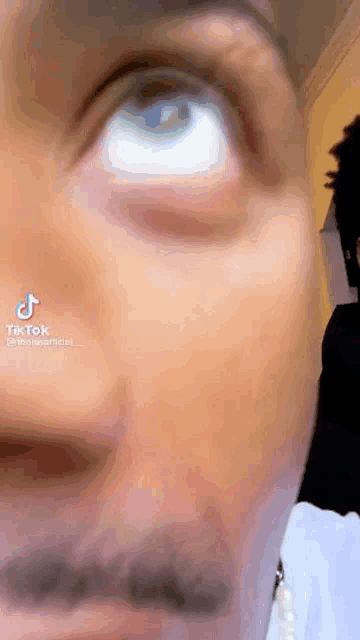 a close up of a person 's face with a beard looking up at the camera .
