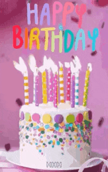 a birthday cake with candles and sprinkles on a plate on a table .