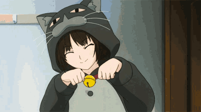 a girl is wearing a cat costume and holding a bell around her neck