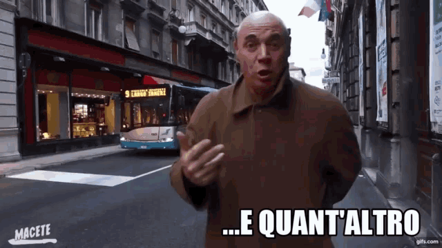 a man stands in front of a bus with the words e quant'altro on the bottom