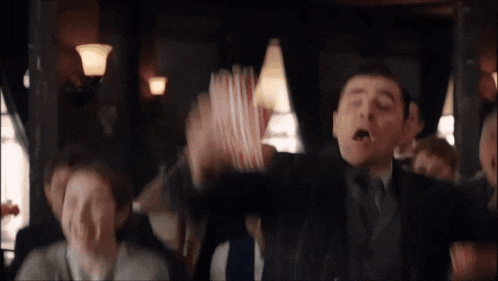 a man in a suit and tie is holding a stack of popcorn